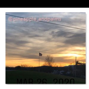 Sunset on a hill with American flag waving in the breeze